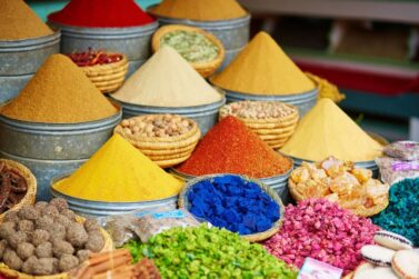 Vibrant Natural Color Food Ingredients in individual stacks, including paprika, turmeric, and other spice powders. HaFSBX Natural Color Handling in Food and Beverage Manufacturing.
